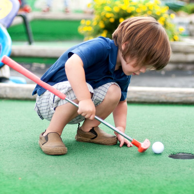 Boy playing putt putt